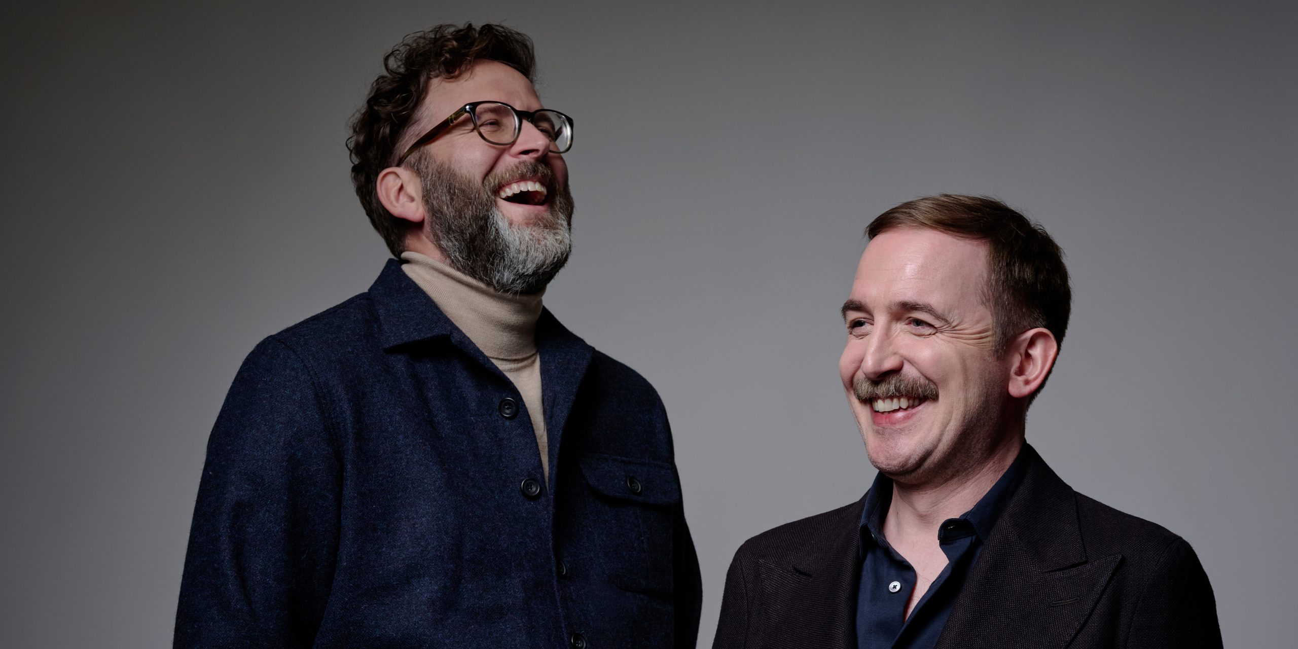 David Reed and Humphrey pose together, smiling, against a neutral background with soft lighting.
